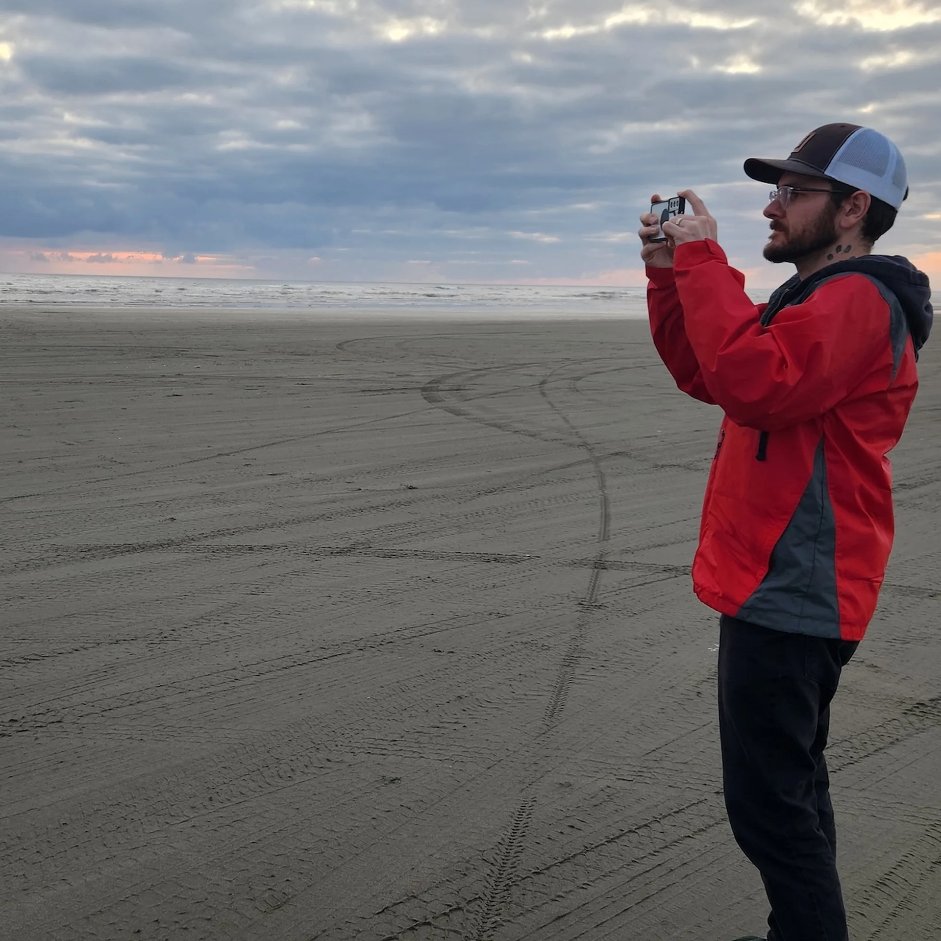 Alex Rindone taking a picture at the beach at sunset